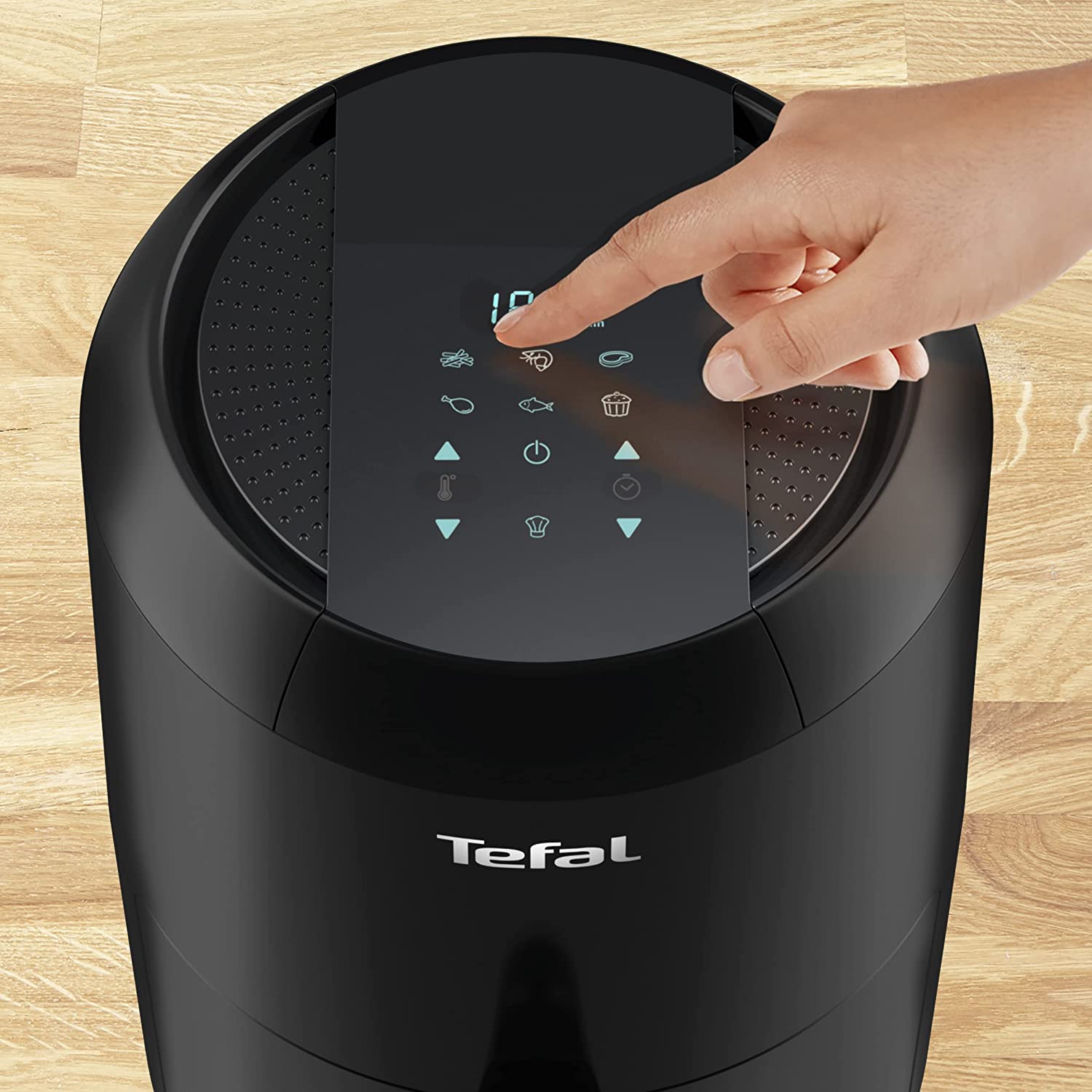 Dessus du Tefal Easy Fry Compact Digital EY3018 noir, dalle tactile bleutée avec pictogrammes de programmes et afficheur, un doigt effleurant une commande