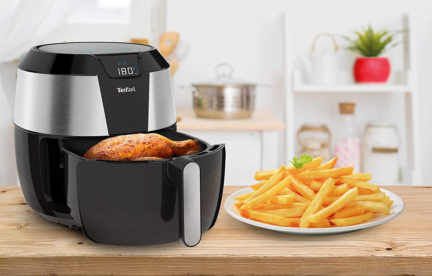 Tefal Easy Fry XXL EY701D tiroir ouvert sur un poulet doré, une assiette de frites croustillantes posée à côté sur un plan de travail en bois