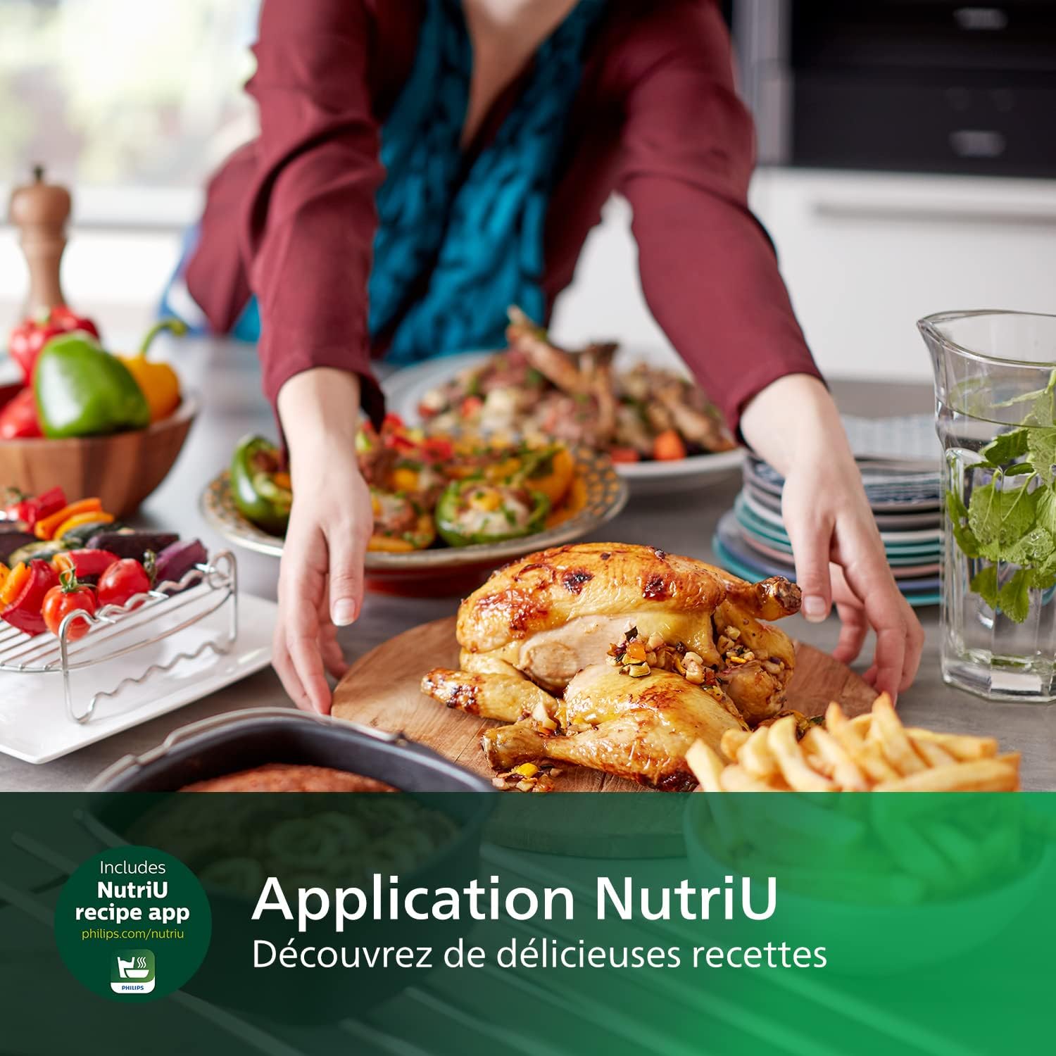 Table dressée autour du Philips Airfryer XXL HD9650/90 avec un poulet entier découpé, des frites, des poivrons farcis et une grille étagée métallique
